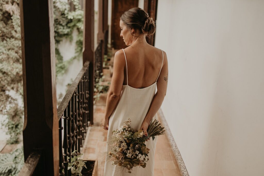 Novia sujeta ramo de flores mientras espera el momento de su boda en Cortijo El Esparragal (Gerena, Sevilla).